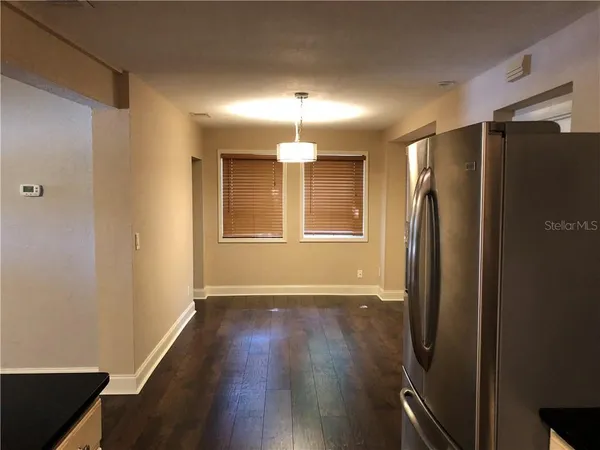 a view of a kitchen with a refrigerator cabinet and wooden floor