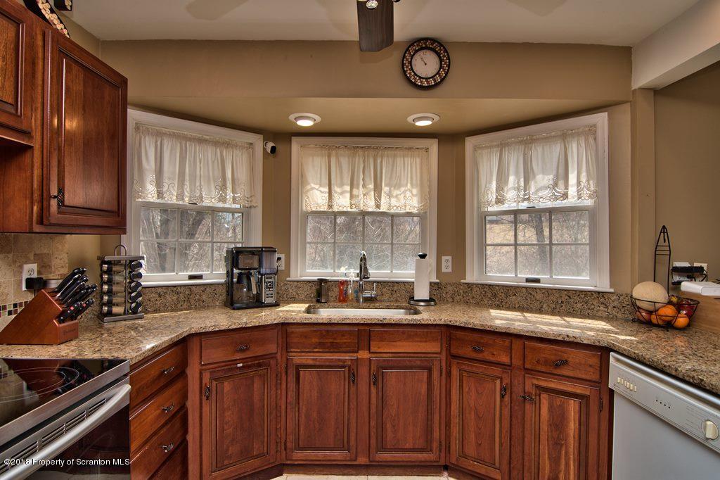 2050 Reservoir Road Moscow, PA 18444 - Photo 19 of 44 a kitchen with stainless steel appliances wooden cabinets a sink and a window
