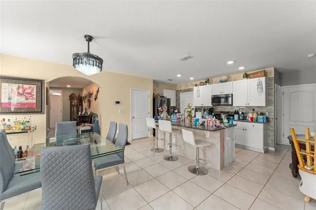 a living room with furniture a dining table and a chandelier