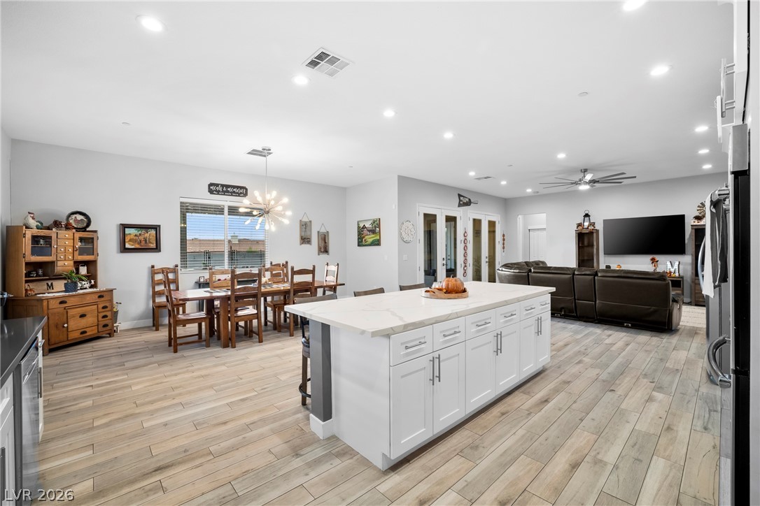 432 North Racetrack Road Henderson, NV 89015 - Photo 44 of 45 Kitchen featuring a center island, white cabinetry, light wood-style floors, and open floor plan