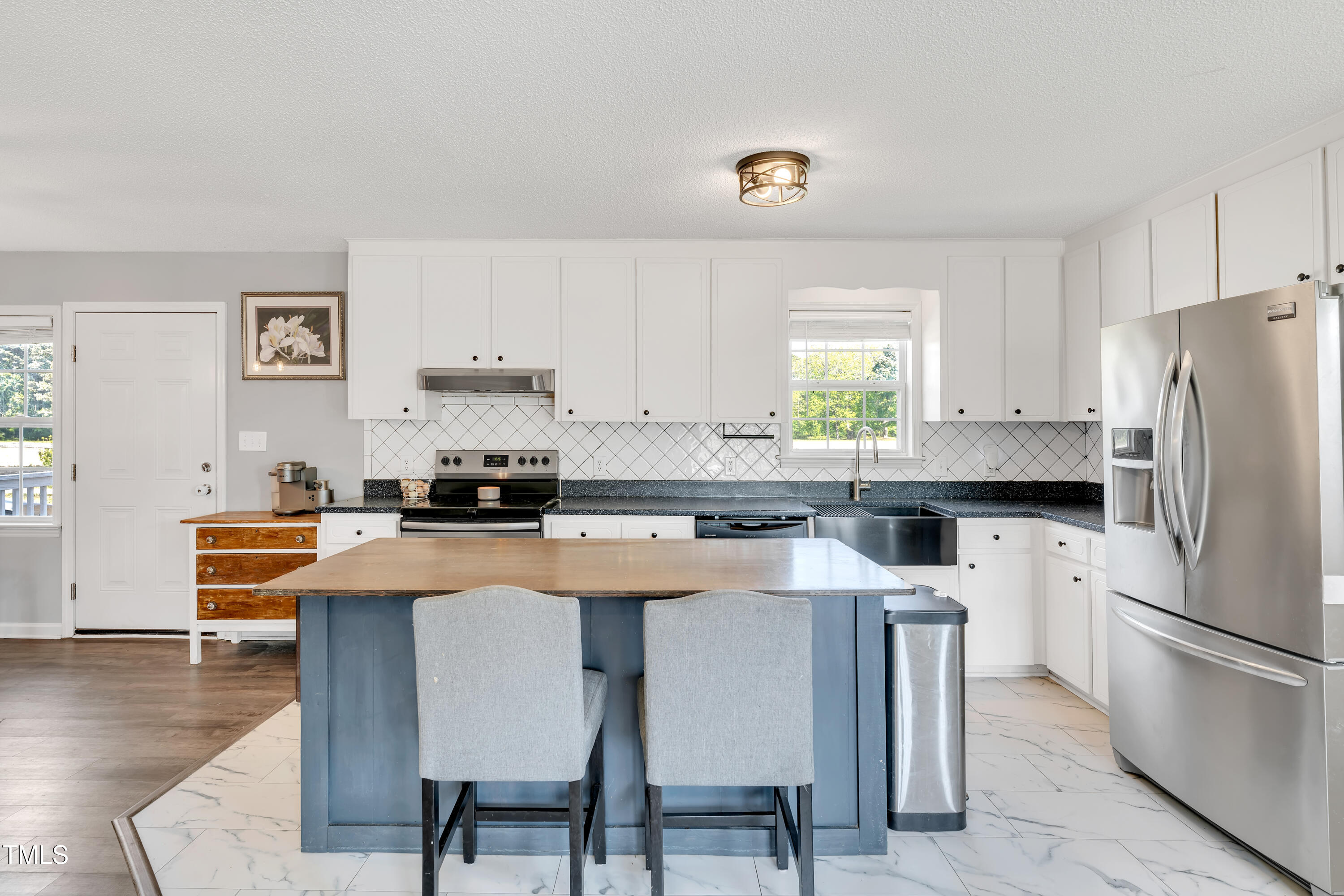 640 Short Journey Road Smithfield, NC 27577 - Photo 5 of 27 a kitchen with stainless steel appliances granite countertop a stove a refrigerator a white table and chairs