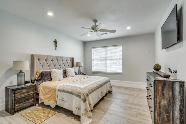 a bedroom with a bed and a flat tv screen on the dresser