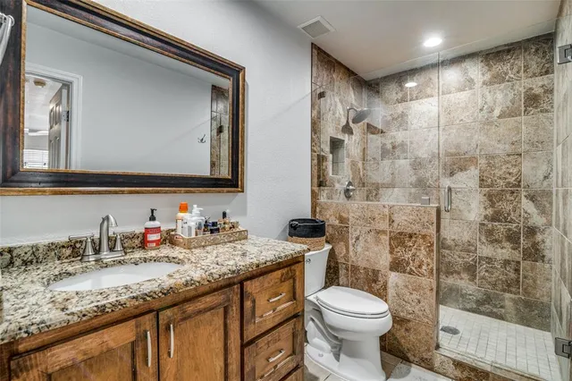 a bathroom with a granite countertop sink toilet and shower