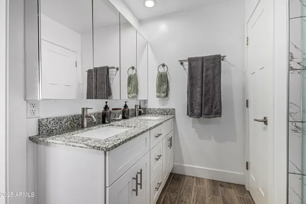 a bathroom with a granite countertop sink and a mirror
