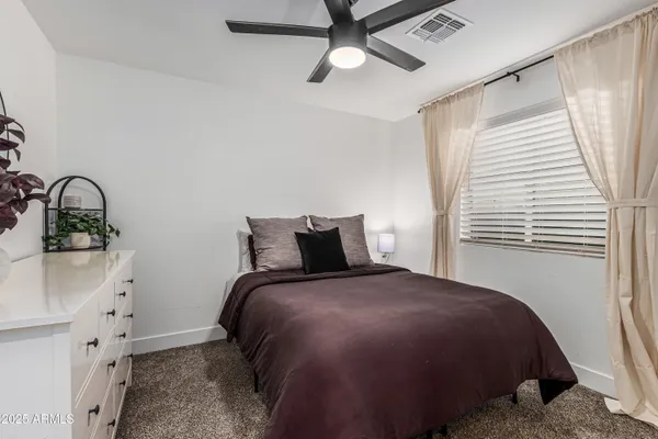 a bedroom with a bed dresser and a window