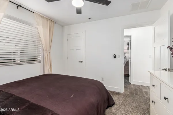 a bedroom with a bed and a chandelier fan