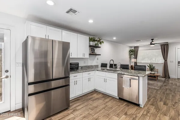 a kitchen with stainless steel appliances a refrigerator a sink a stove a microwave and island