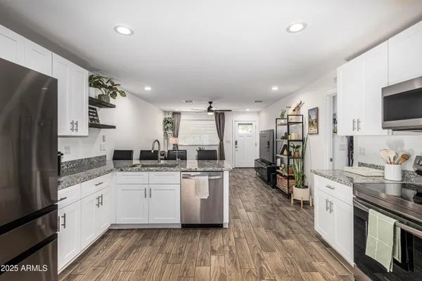 a kitchen with white cabinets and stainless steel appliances
