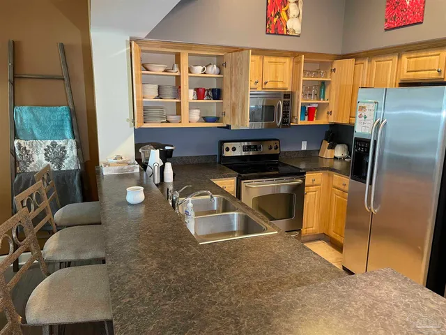 a kitchen with stainless steel appliances granite countertop a stove a sink and a refrigerator