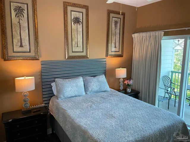 a bedroom with a bed and a lamp on dresser