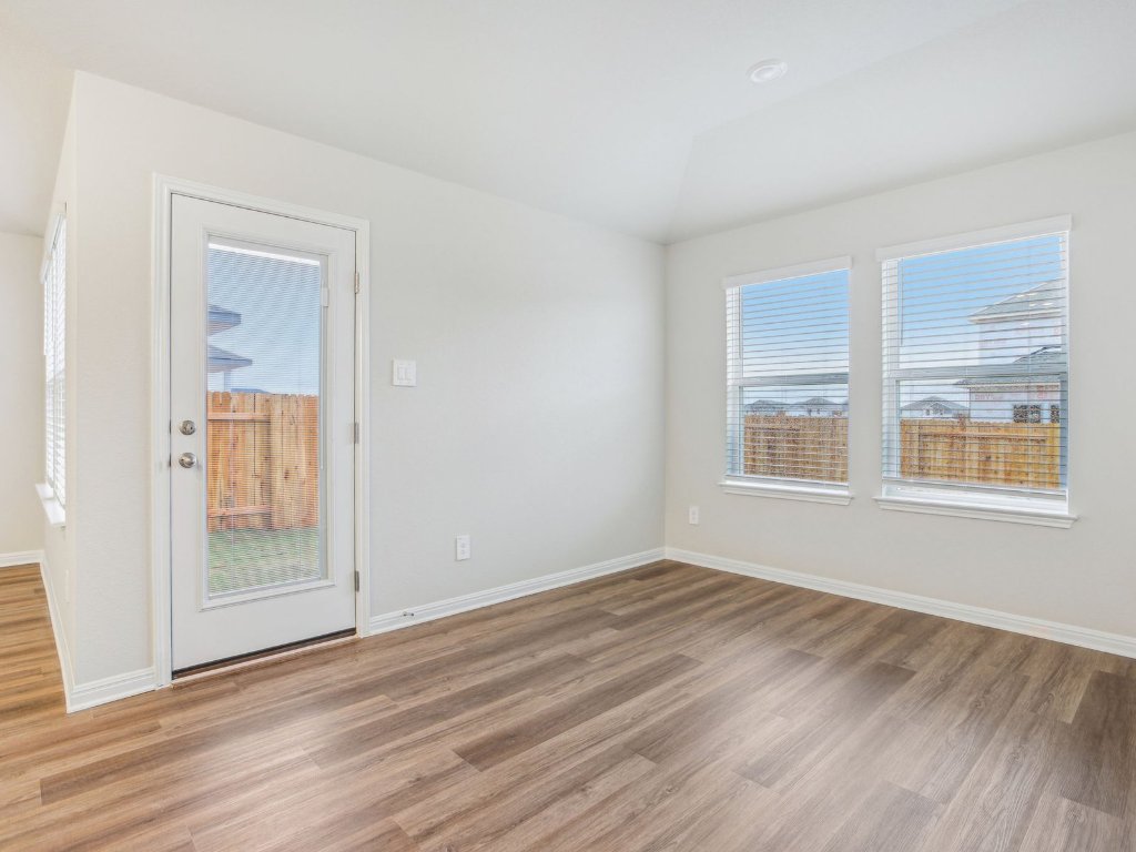 104 Honey Bee Road Jarrell, TX 76537 - Photo 10 of 17 a view of an empty room with wooden floor with windows