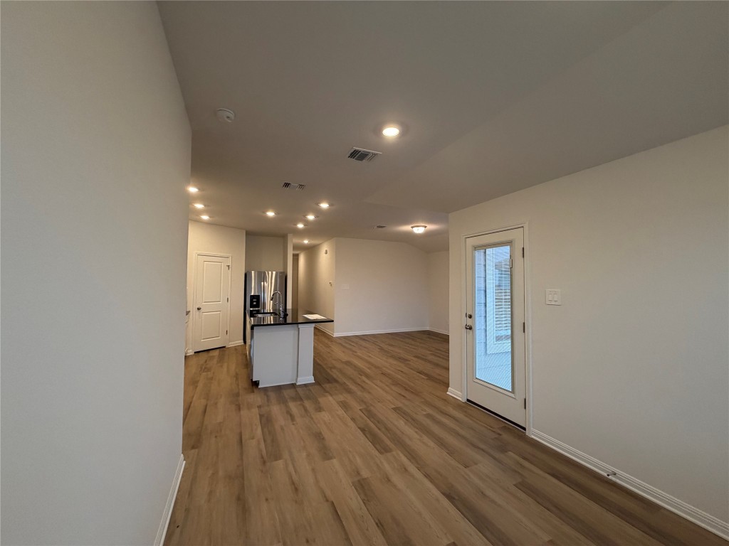 104 Honey Bee Road Jarrell, TX 76537 - Photo 16 of 17 Kitchen with dark countertops, open floor plan, recessed lighting, a center island with sink, and dark wood-style floors