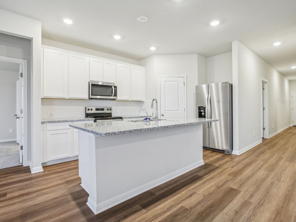 104 Honey Bee Road Jarrell, TX 76537 - Photo 7 of 17 a kitchen with stainless steel appliances granite countertop a refrigerator stove and a sink