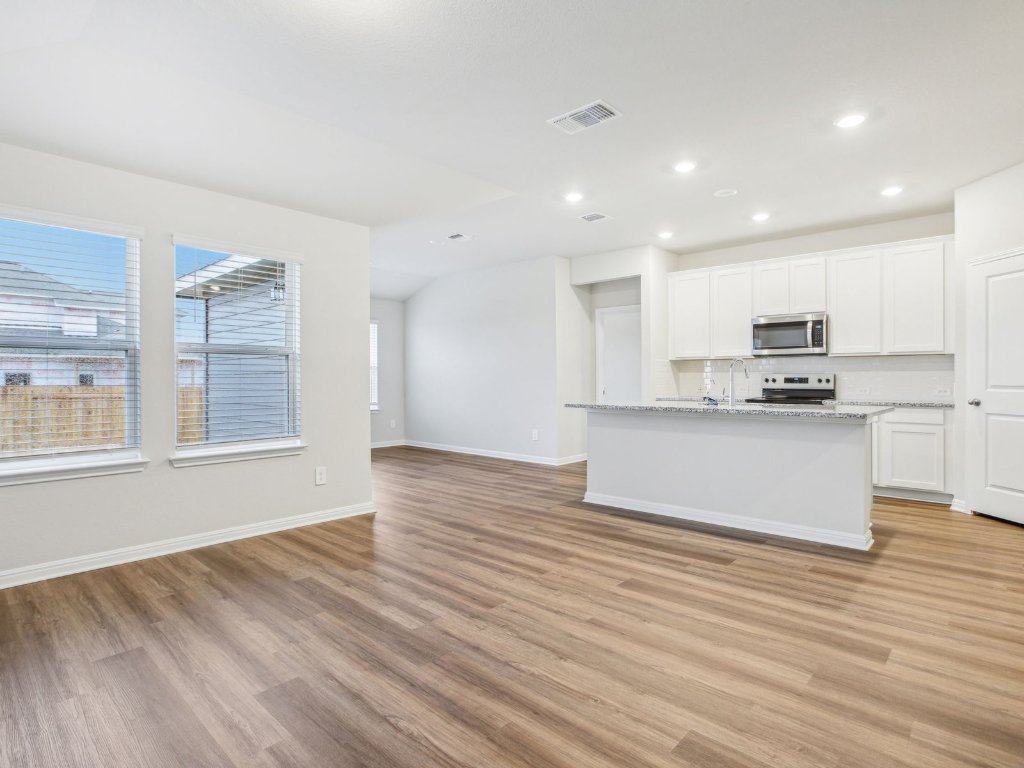104 Honey Bee Road Jarrell, TX 76537 - Photo 8 of 17 a view of kitchen with granite countertop cabinets and wooden floor