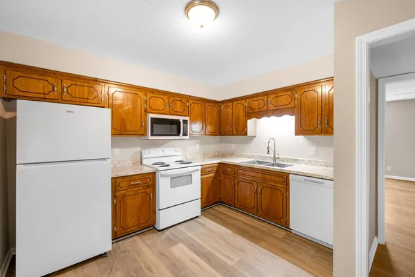 a kitchen with stainless steel appliances granite countertop a refrigerator a stove a sink and a microwave