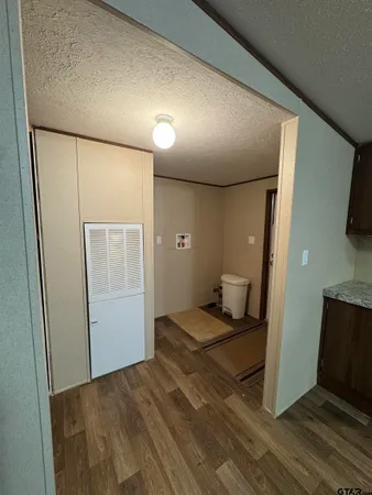 a view of a livingroom with wooden floor and a bathroom