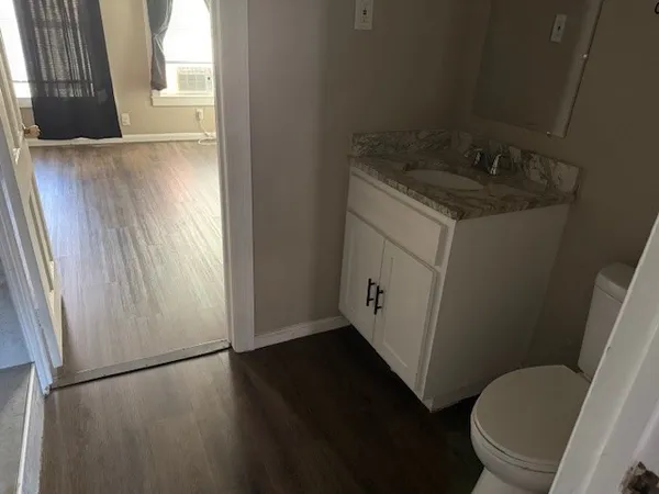a bathroom with a granite countertop sink toilet and a tub