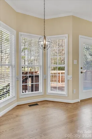 a view of a livingroom with a chandelier fan and windows