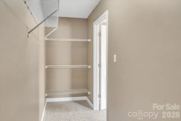 a view of walk in closet with empty racks