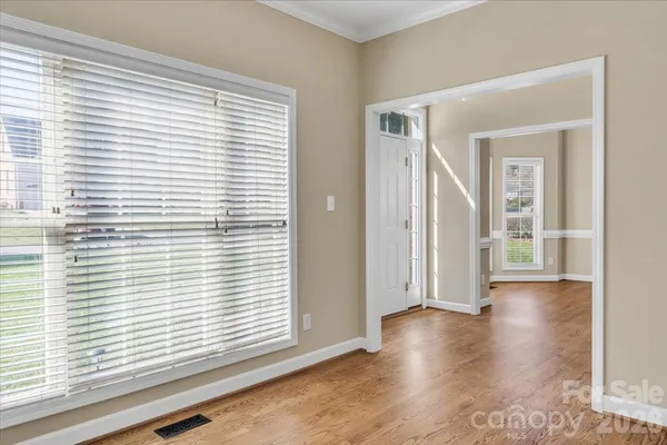 a view of a livingroom with wooden floor and a large window