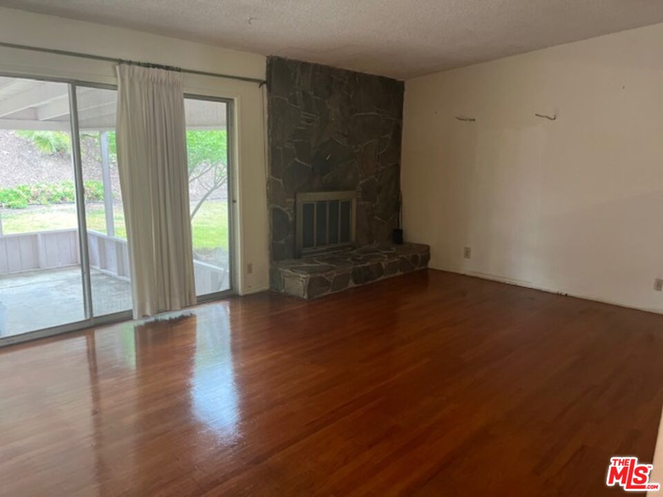 18665 Horace Street Porter Ranch, CA 91326 - Photo 12 of 13 a view of an empty room with wooden floor and a window