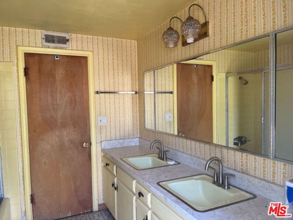 18665 Horace Street Porter Ranch, CA 91326 - Photo 4 of 13 a bathroom with a granite countertop sink a mirror and shower