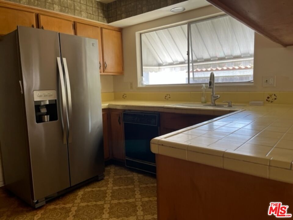 18665 Horace Street Porter Ranch, CA 91326 - Photo 5 of 13 a kitchen with a sink a refrigerator and a window