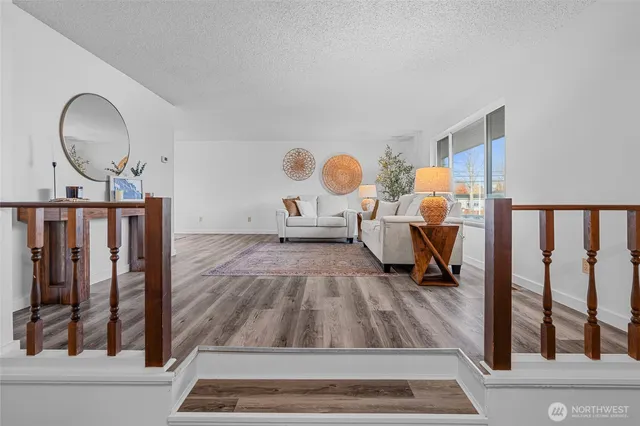a view of a livingroom with wooden floor and furniture