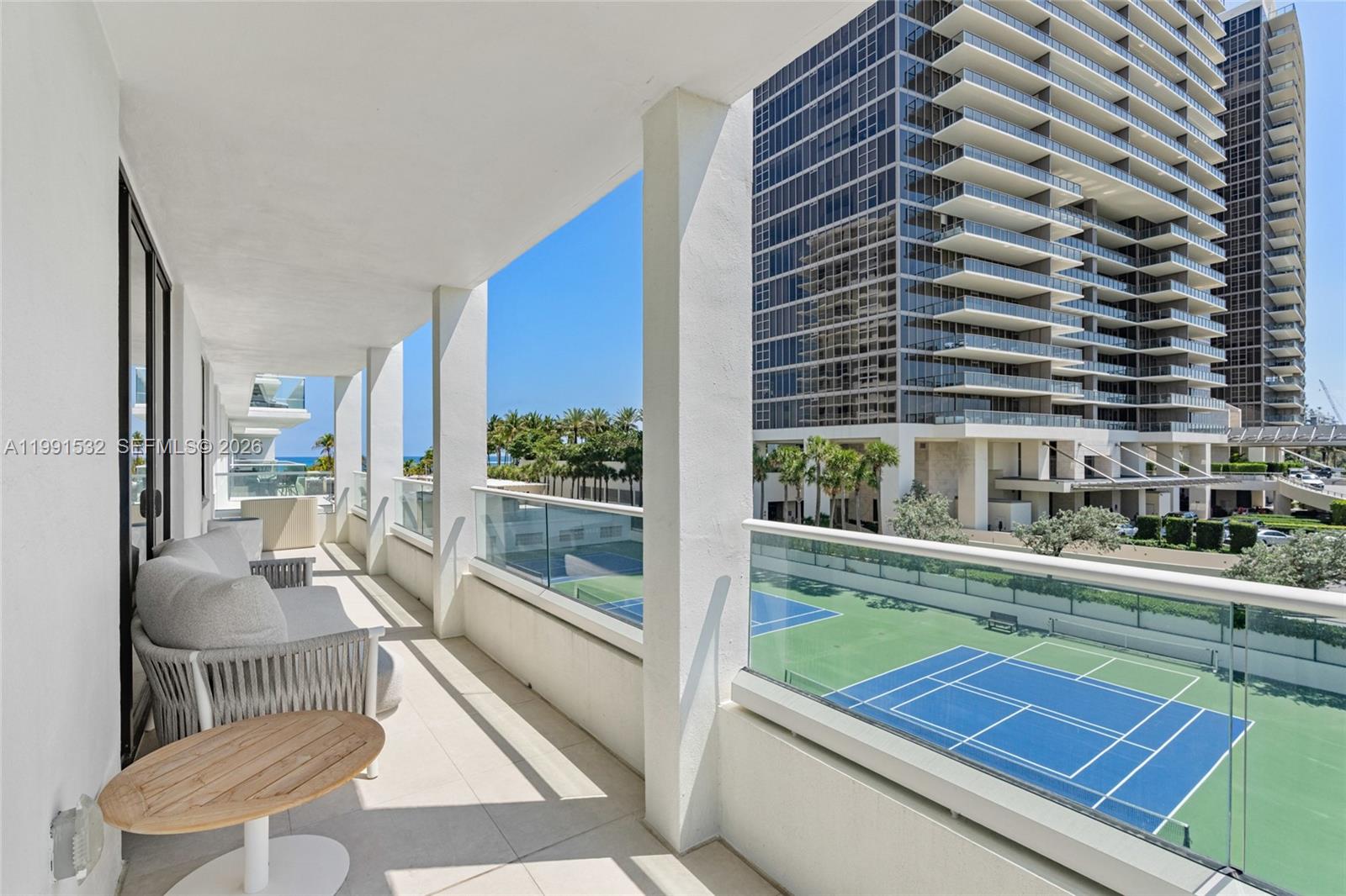9801 Collins Avenue, Unit 5R Bal Harbour, FL 33154 - Photo 32 of 47 a balcony with couch and wooden floor
