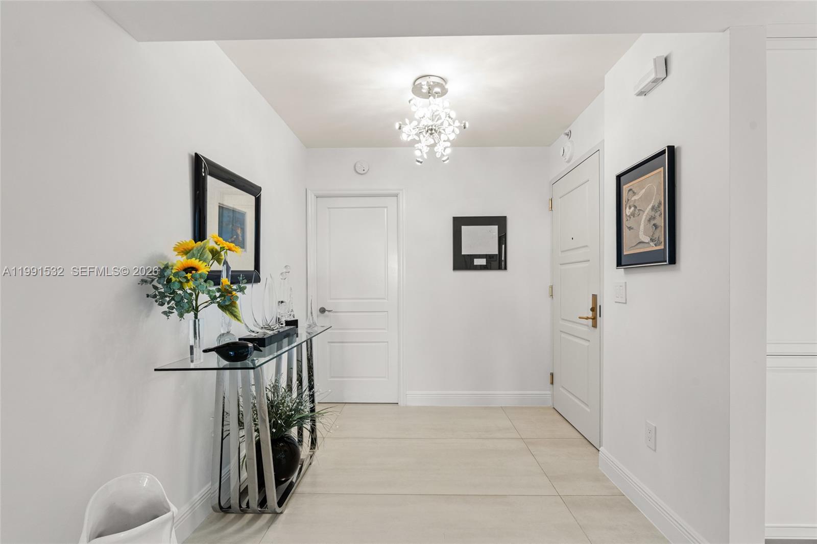 9801 Collins Avenue, Unit 5R Bal Harbour, FL 33154 - Photo 6 of 47 a view of a hallway with chandelier and a chandelier