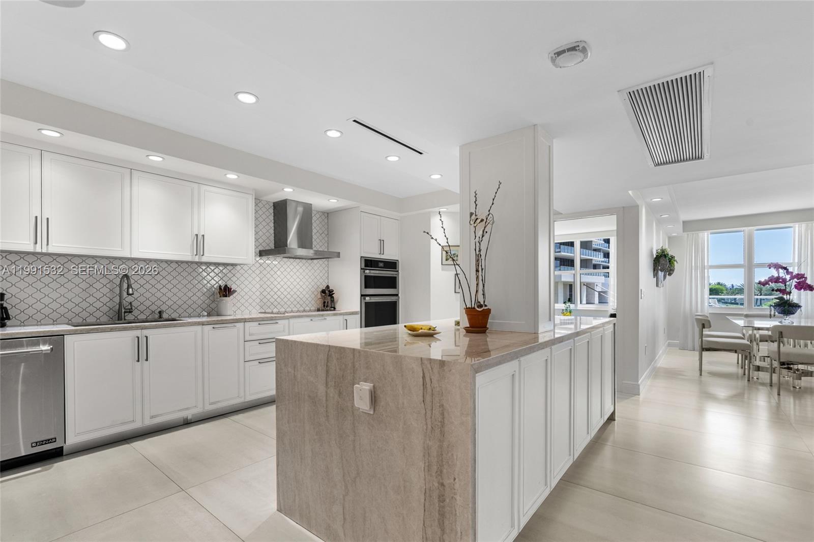 9801 Collins Avenue, Unit 5R Bal Harbour, FL 33154 - Photo 8 of 47 a kitchen with stainless steel appliances granite countertop a refrigerator and a stove top oven