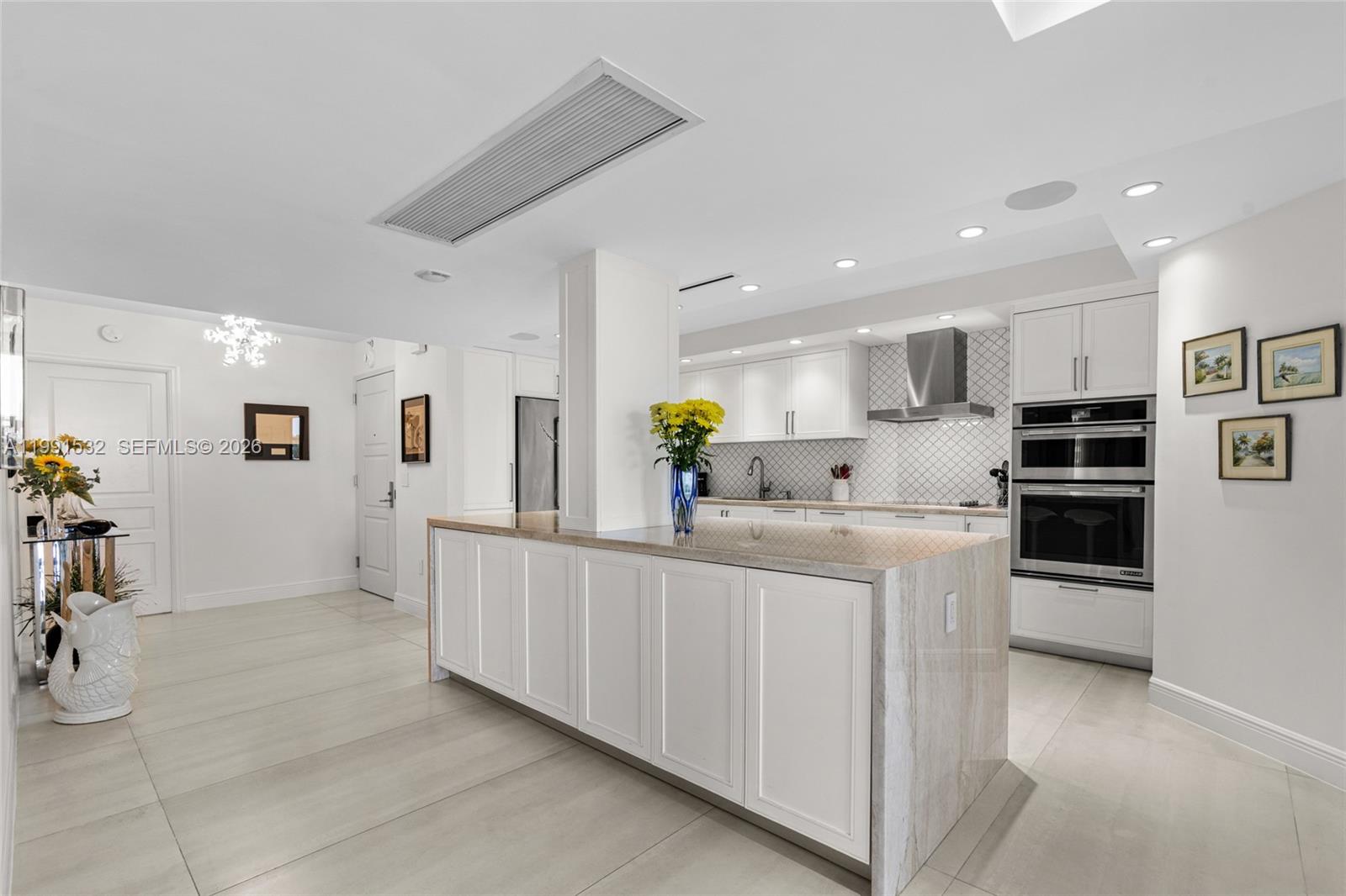 9801 Collins Avenue, Unit 5R Bal Harbour, FL 33154 - Photo 9 of 47 a kitchen with white cabinets and refrigerator