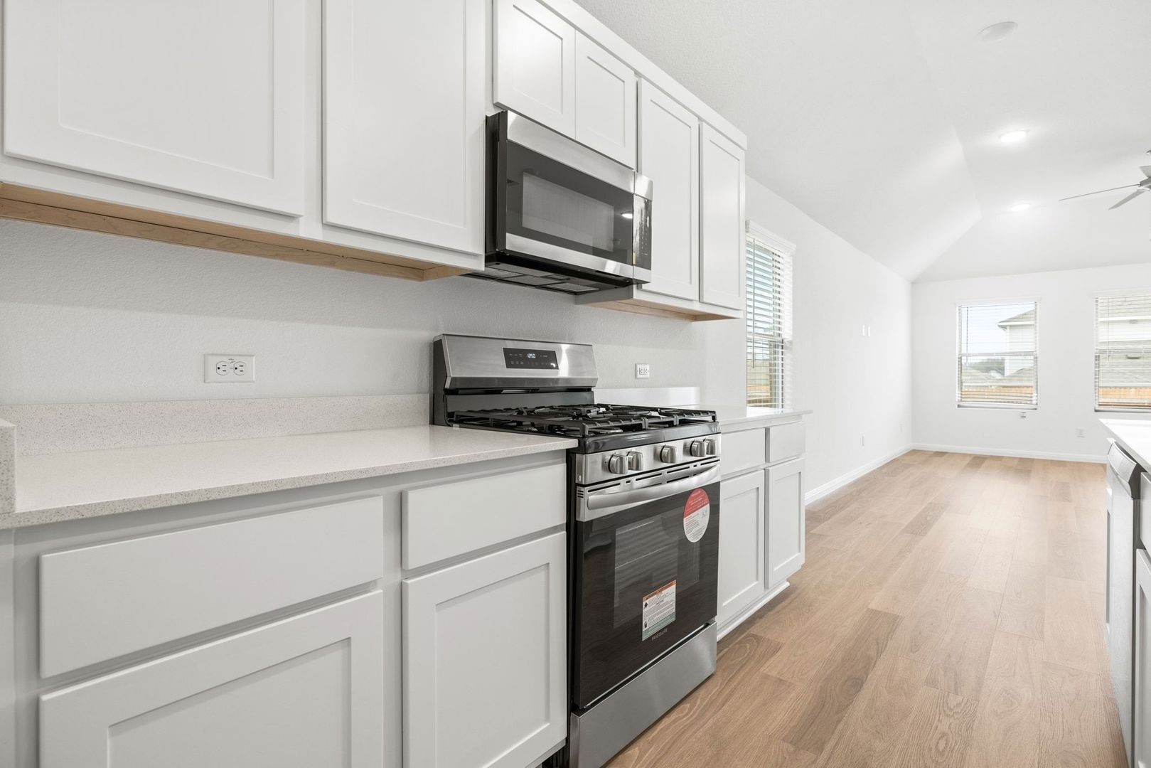 222 Spirit Street Elgin, TX 78621 - Photo 10 of 40 a kitchen with stainless steel appliances granite countertop a stove a sink and a microwave