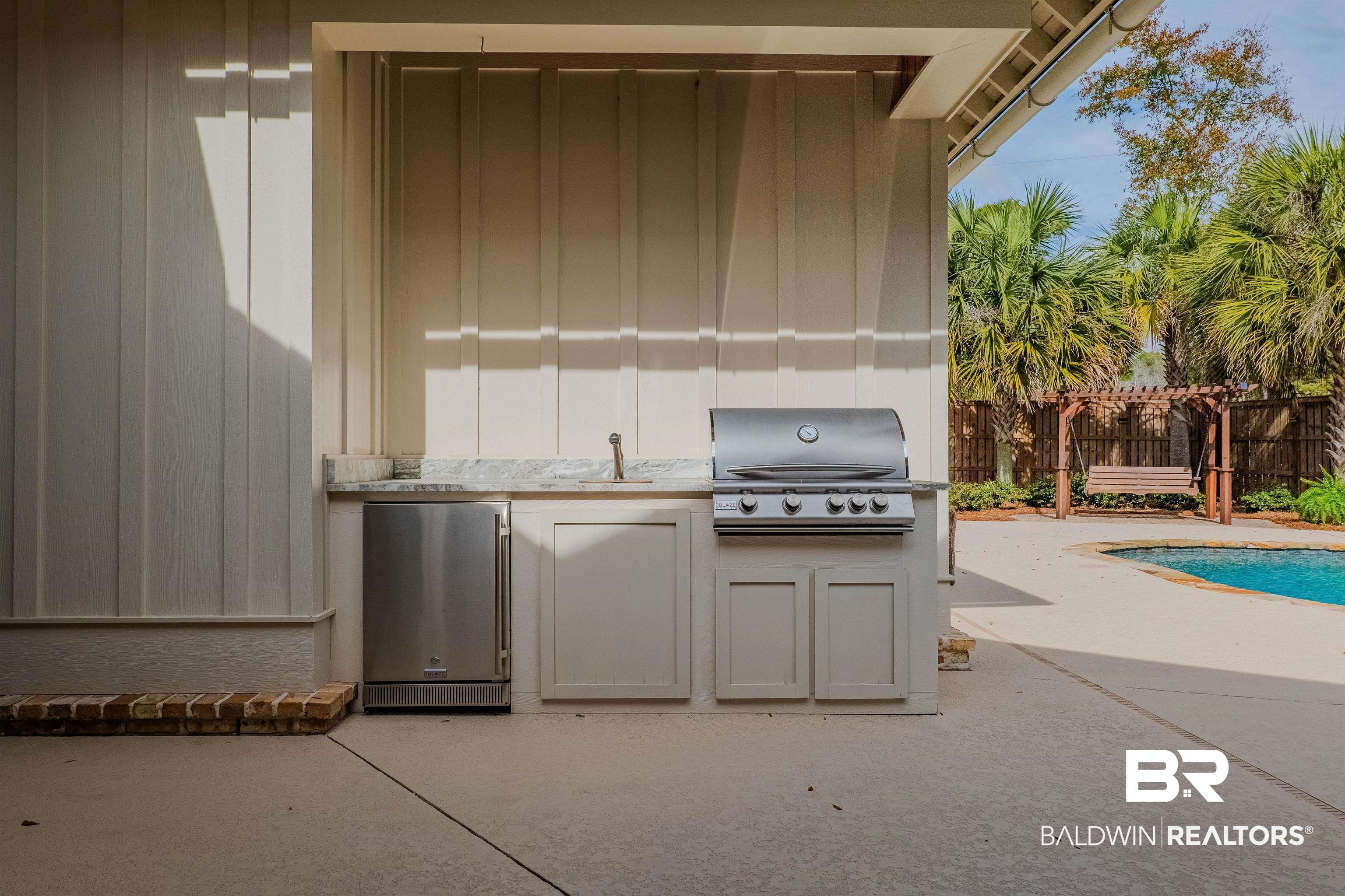 708 Manning Place Fairhope, AL 36532 - Photo 47 of 58 View of patio featuring a grill, sink, a fenced in pool, and an outdoor kitchen