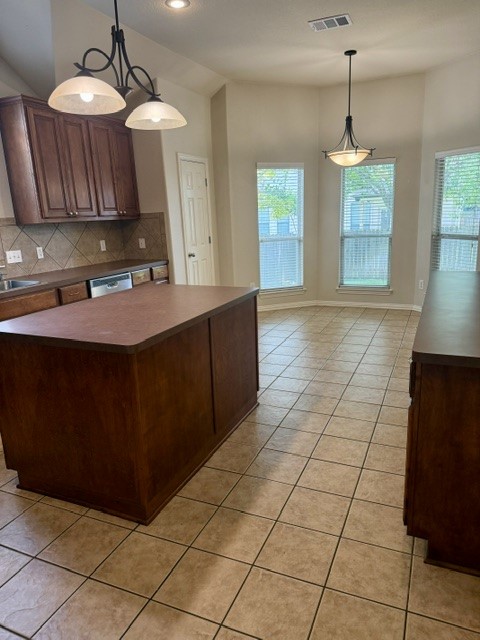 20724 Kearney Hill Road Pflugerville, TX 78660 - Photo 15 of 40 Spacious kitchen featuring an expansive center island, warm wood cabinetry, ceramic tile flooring, and a dining area with multiple windows