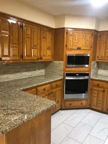 a kitchen with stainless steel appliances granite countertop a stove and a microwave