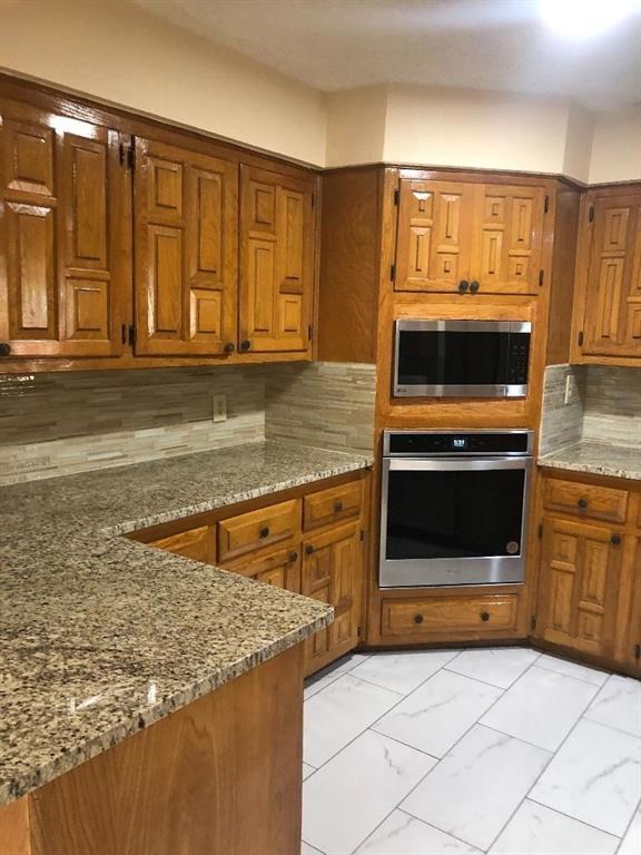 222 Syracuse Place Richardson, TX 75081 - Photo 4 of 13 a kitchen with stainless steel appliances granite countertop a stove and a microwave