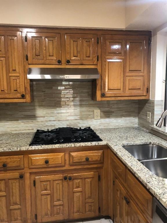 222 Syracuse Place Richardson, TX 75081 - Photo 5 of 13 a kitchen with granite countertop a stove sink and cabinets