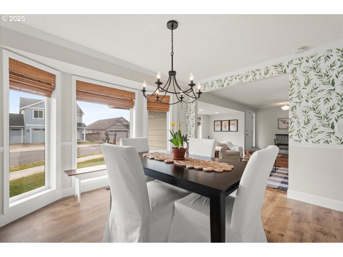 2018 North 4th Way Ridgefield, WA 98642 - Photo 9 of 39 a dining room with furniture a chandelier and wooden floor