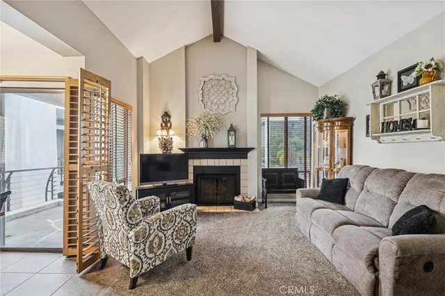 a living room with furniture a fireplace and a large window