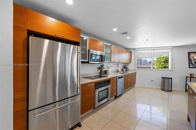 a kitchen with stainless steel appliances a refrigerator sink and microwave