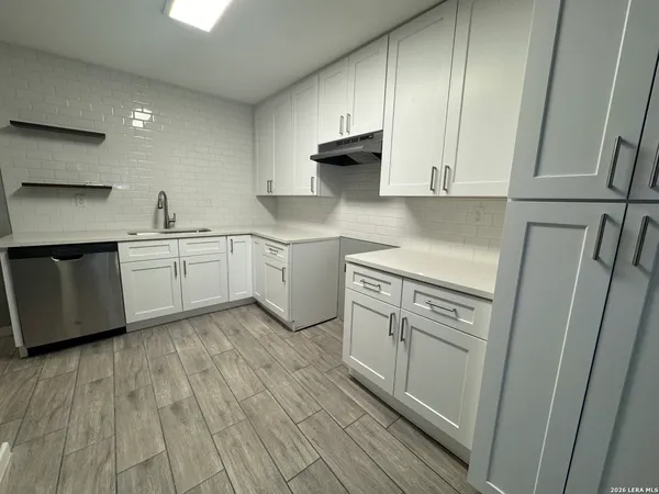 a kitchen with white cabinets and white appliances