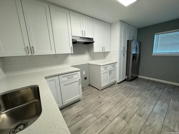 a kitchen with a sink a refrigerator and cabinets