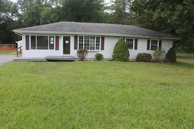 a view of a house with backyard sitting area and garden