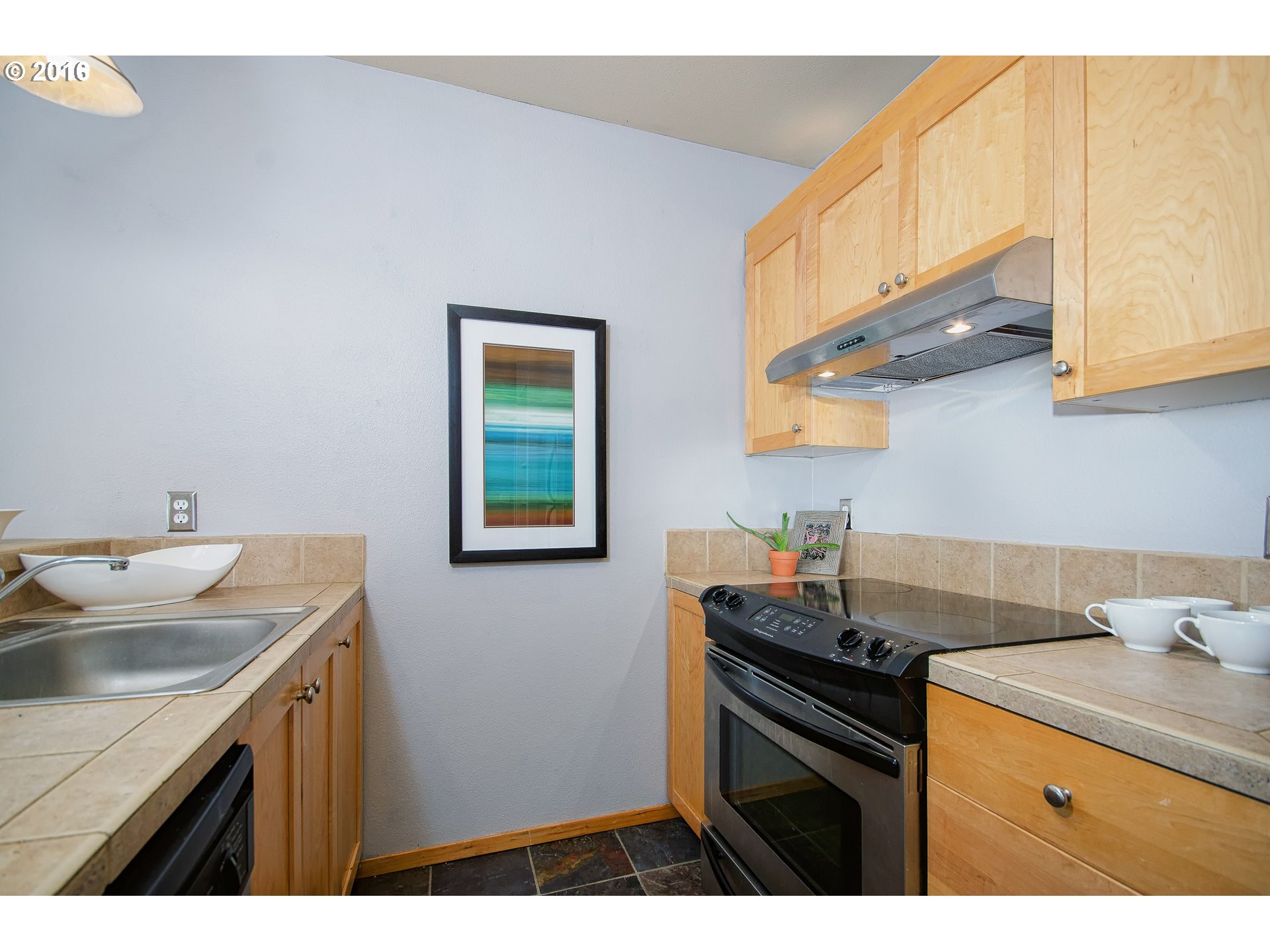 423 Northwest Uptown Terrace, Unit 1B Portland, OR 97210 - Photo 15 of 23 a kitchen with a sink cabinets and a wooden floor