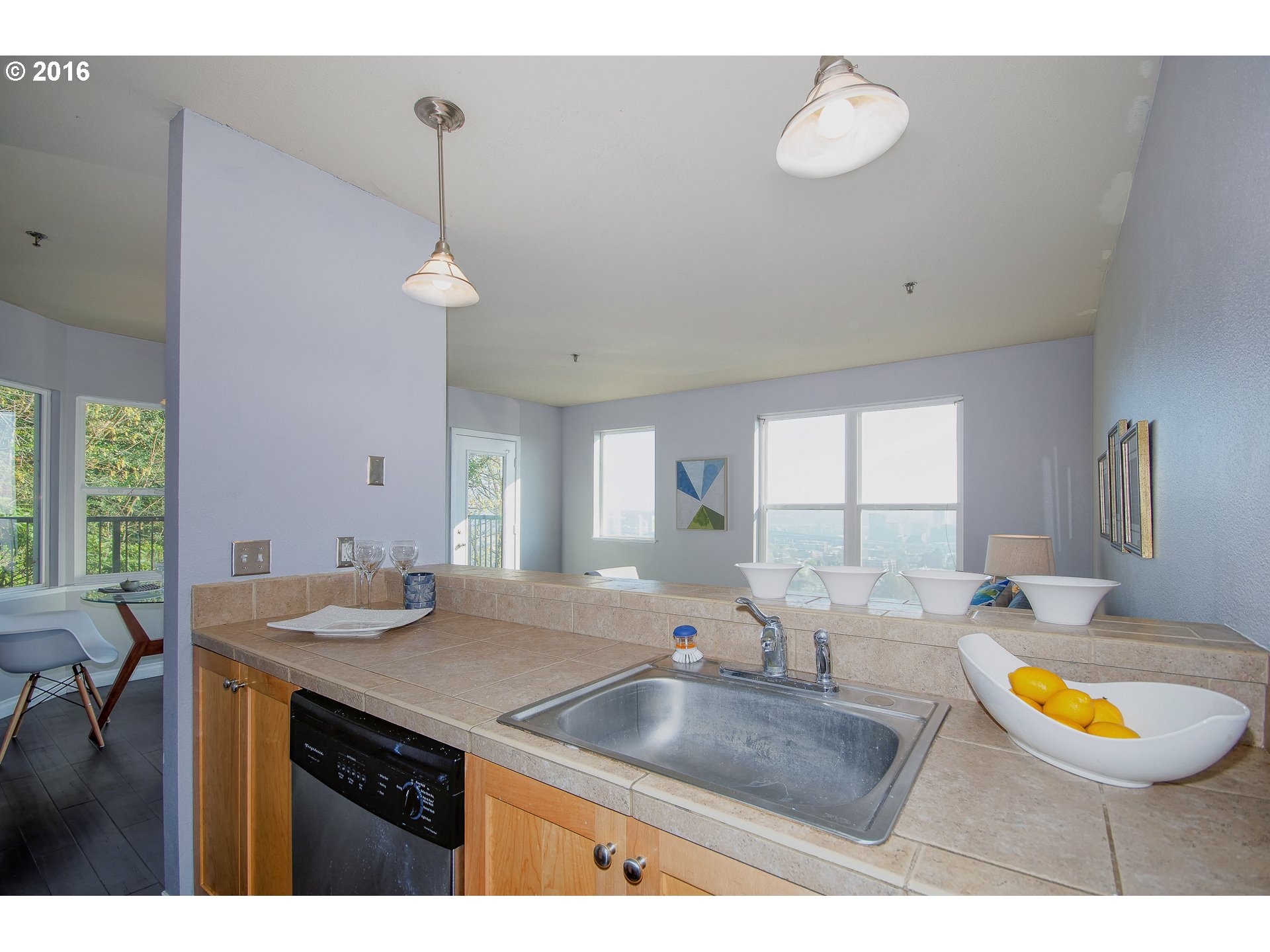 423 Northwest Uptown Terrace, Unit 1B Portland, OR 97210 - Photo 16 of 23 a view of a kitchen island a chandelier and a sink