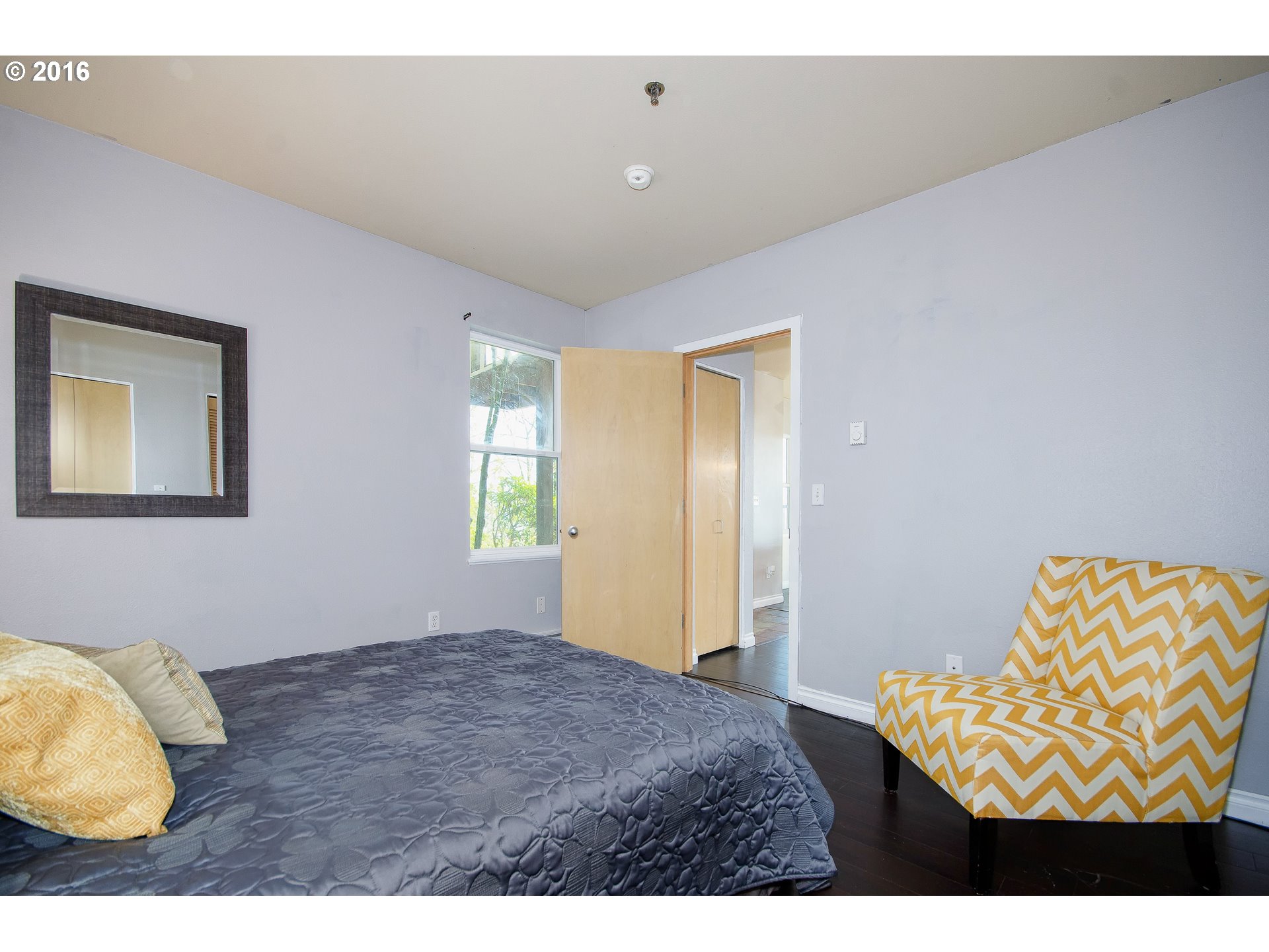 423 Northwest Uptown Terrace, Unit 1B Portland, OR 97210 - Photo 18 of 23 a bedroom with a bed and a painting on the wall