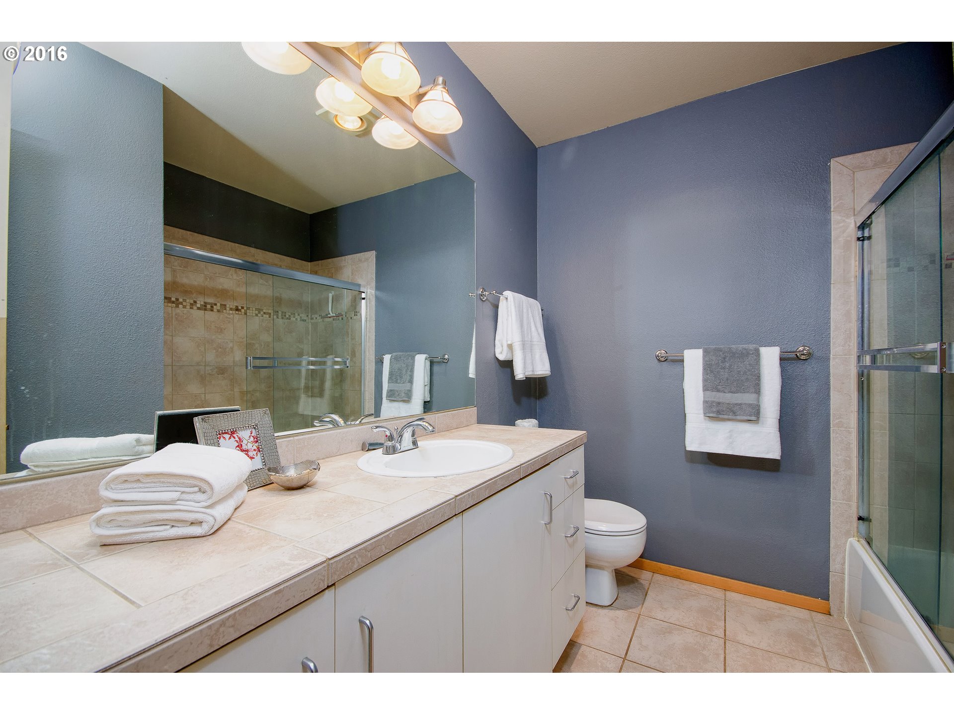 423 Northwest Uptown Terrace, Unit 1B Portland, OR 97210 - Photo 19 of 23 a bathroom with a sink a toilet and a mirror