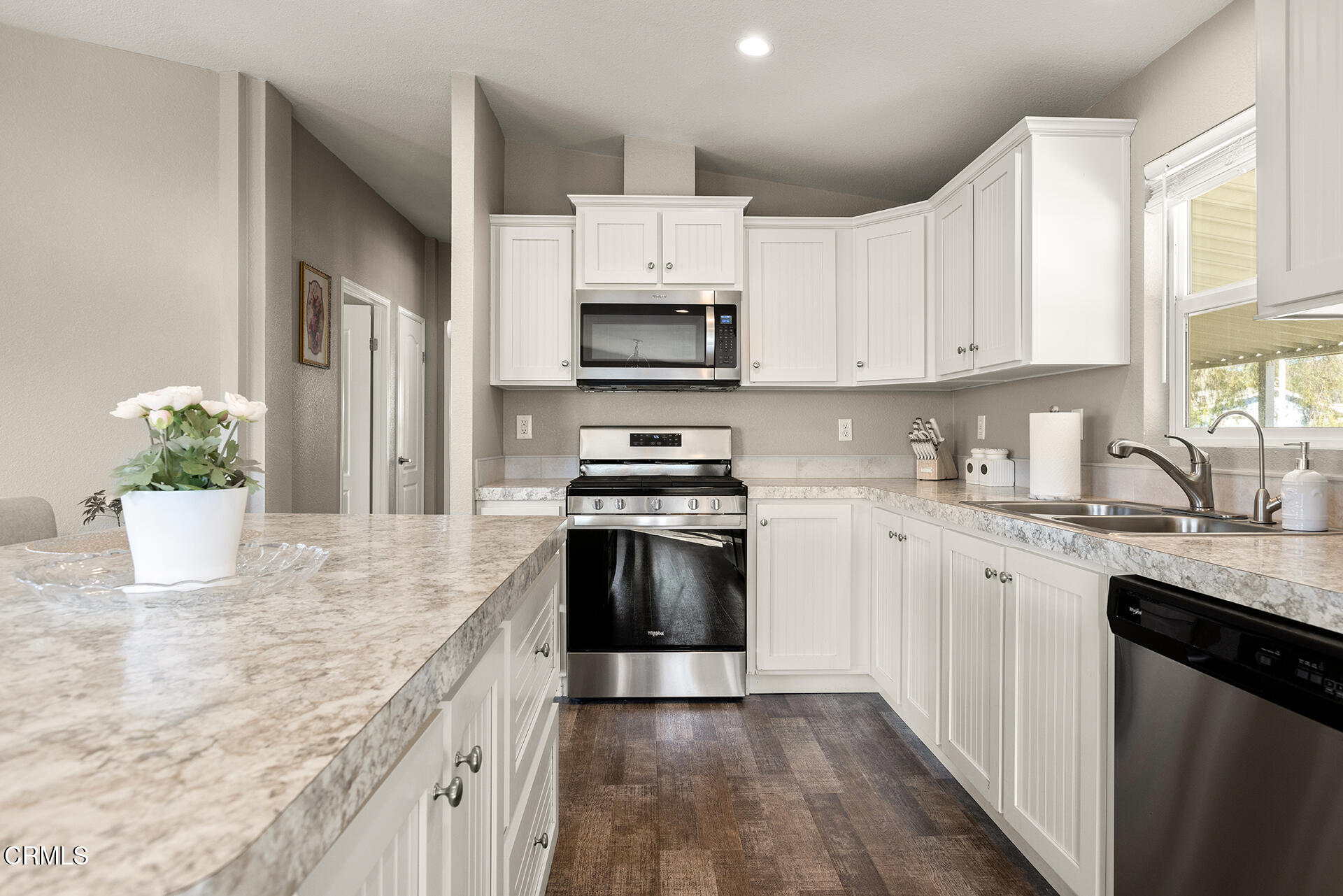 1500 Richmond Road, Unit 64 Santa Paula, CA 93060 - Photo 5 of 11 a kitchen with granite countertop white cabinets and stainless steel appliances