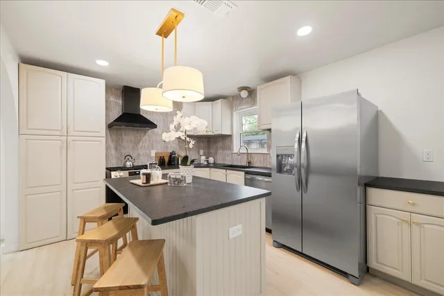 a kitchen with stainless steel appliances granite countertop a sink a refrigerator and a stove